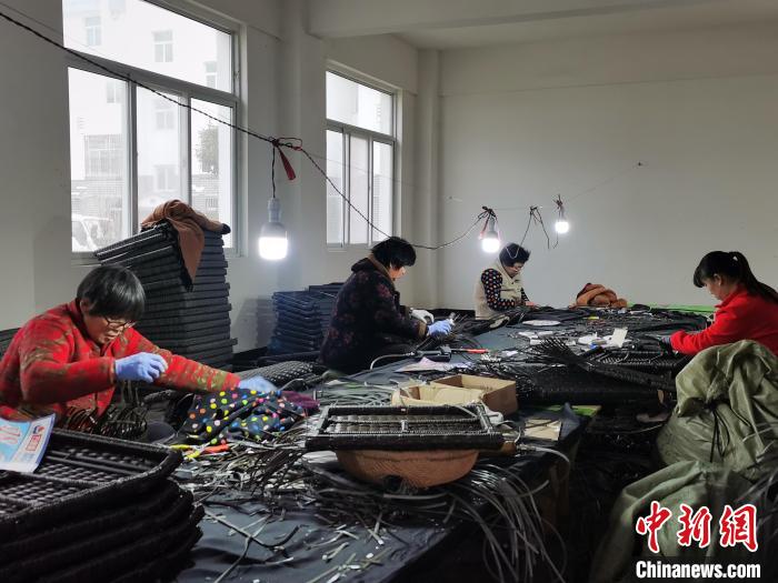 圖為范縣張莊鎮(zhèn)鳳凰社區(qū)里正在做手工藤編的村民?！Ⅸi 攝