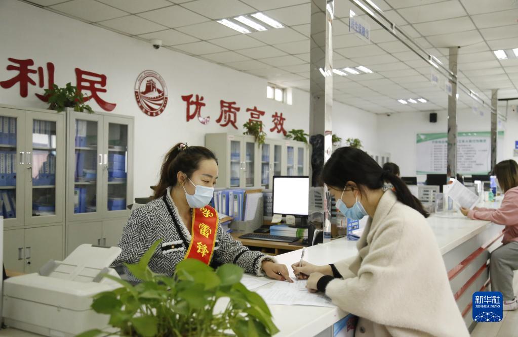 河北省邢臺市襄都區(qū)宴家屯鎮(zhèn)綜合服務中心工作人員協(xié)助辦事群眾填寫相關(guān)表格（2022年3月30日攝）。